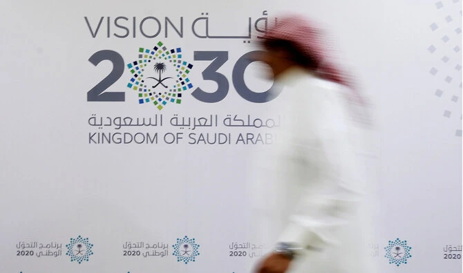 A Saudi man walks past the logo of Vision 2030 after a news conference in Jeddah, Saudi Arabia. Reuters/File