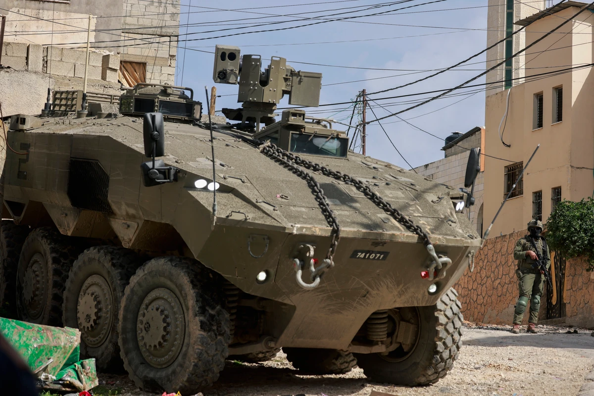 Israeli soldiers stand guar near their armoured vehicles as they conduct a raid in the eastern neighbourhood of Jenin amid a weeks-long offensive in the occupied West Bank, March 4, 2025. (AFP)