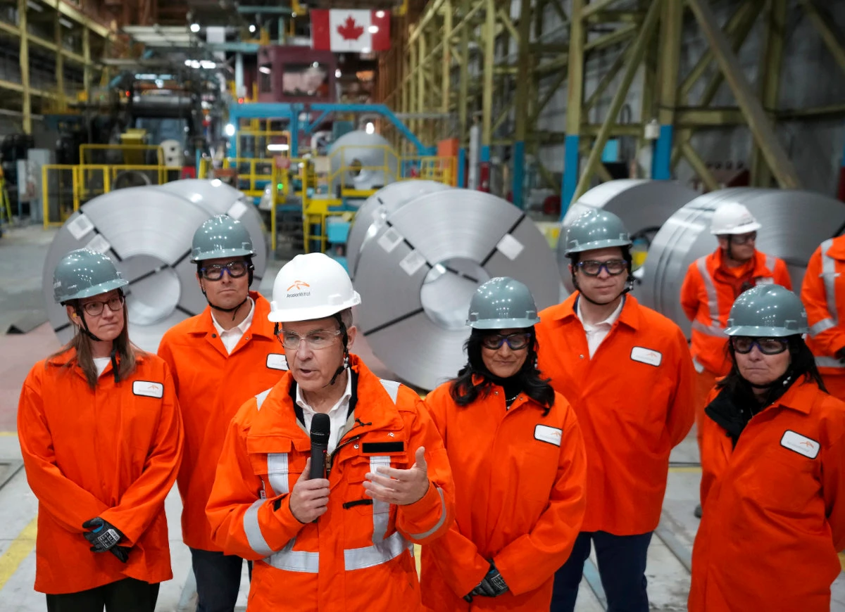 Canadian Prime Minister designate Mark Carney, third left, speaks to steel workers after touring the ArcelorMittal Dofasco steel plant in Hamilton, Ont., on March 12, 2025. (The Canadian Press via AP)
