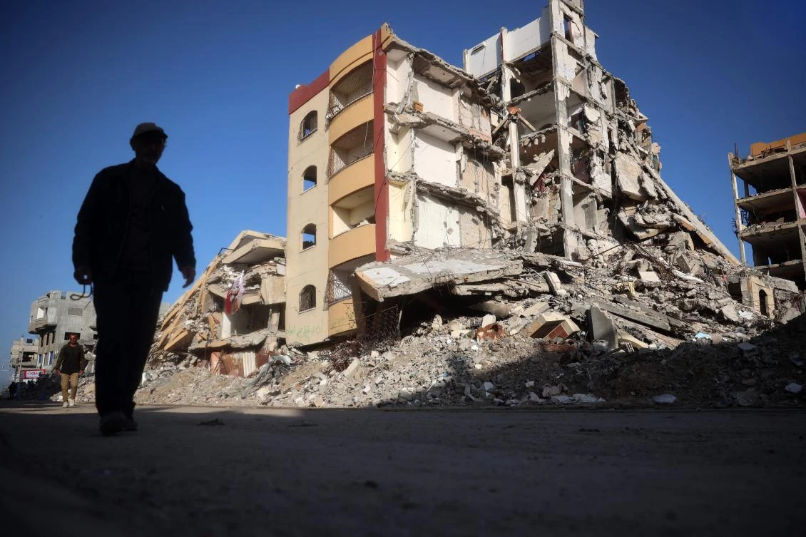 Palestinians walk in a war-devastated neighbourhood in the Nuseirat refugee camp in the central Gaza Strip on March 14, 2025. (AFP)