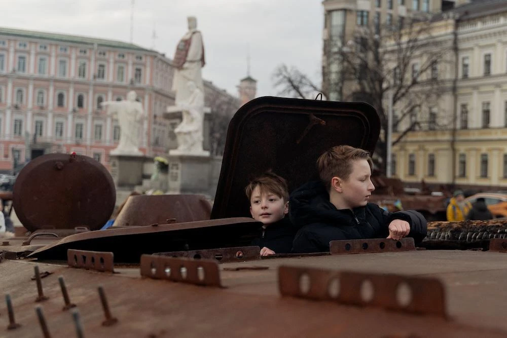 Children climb on a destroyed Russian personnel carrier at an open-air exhibition on Mykhailivska Square in Kyiv on Jan. 8, 2025. (AFP)