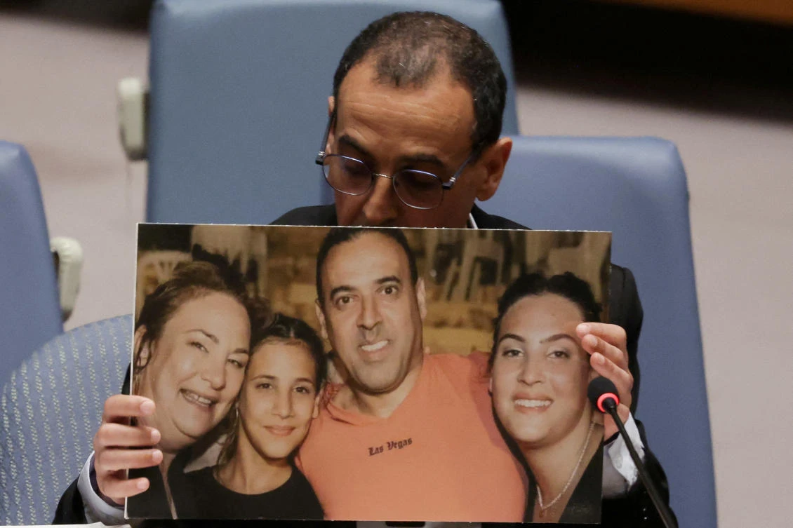 Eli Sharabi, a former Israeli hostage released by Hamas in Gaza last month, holds of a photograph of his wife and two daughters killed by Hamas, as he addresses a meeting of the UN Security Council at the UN headquarters in New York, Mar. 20, 2025. (Reuters)