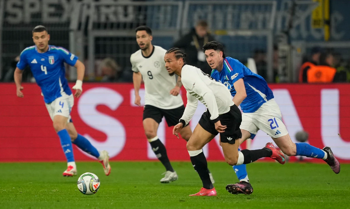 Germany's Leroy Sane, centre, and Italy's Alessandro Bastoni, right, challenge for the ball during the Nations League quarterfinal second leg soccer match between Germany and Italy at the Signal-Iduna Park in Dortmund, Germany, Sunday, March 23, 2025. (AP)