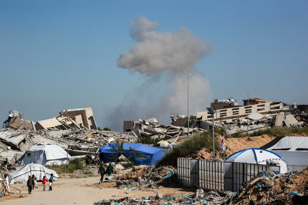 A plume of smoke erupts from a demolition carried out by Israeli forces on a Palestinian building in Beit Lahia in the northern Gaza Strip on March 24, 2025. (AFP)
