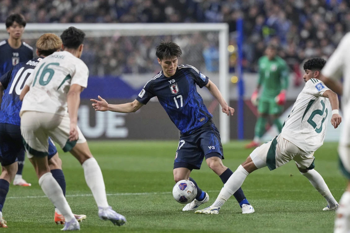 Japan's Ao Tanaka, center, and Saudi Arabia's Ziyad Aljohani battle for control the ball during the World Cup 2026 group C qualifying soccer match between Japan and Saudi Arabia at Saitama Stadium 2002 in Saitama, north of Tokyo, Tuesday, March 25, 2025. (AP)