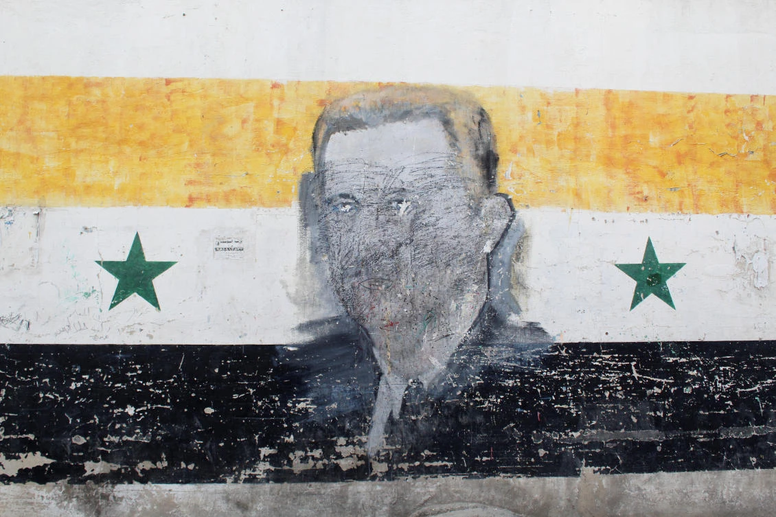 A wall painted with a damaged drawing of ousted Syrian President Bashar Assad is pictured in the Al-Qadam neighborhood in Damascus, Mar. 26, 2025. (Reuters)