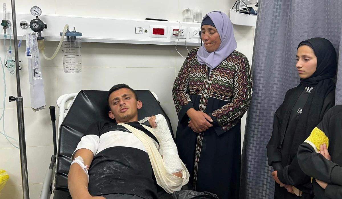 Palestinian Qusai Al-Amur sits in a hospital bed next to his relatives following an attack by Israeli settlers on his West Bank village of Jinba, Friday, March 28, 2025. (AP)
