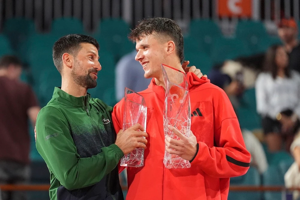 Jakub Mensik, of Czech Republic, holds the Butch Buchholz Championship Trophy after defeating Novak Djokovic, of Serbia, left, in the men’s singles final match at the Miami Open tennis tournament Sunday in Miami Gardens, Florida. (AP)