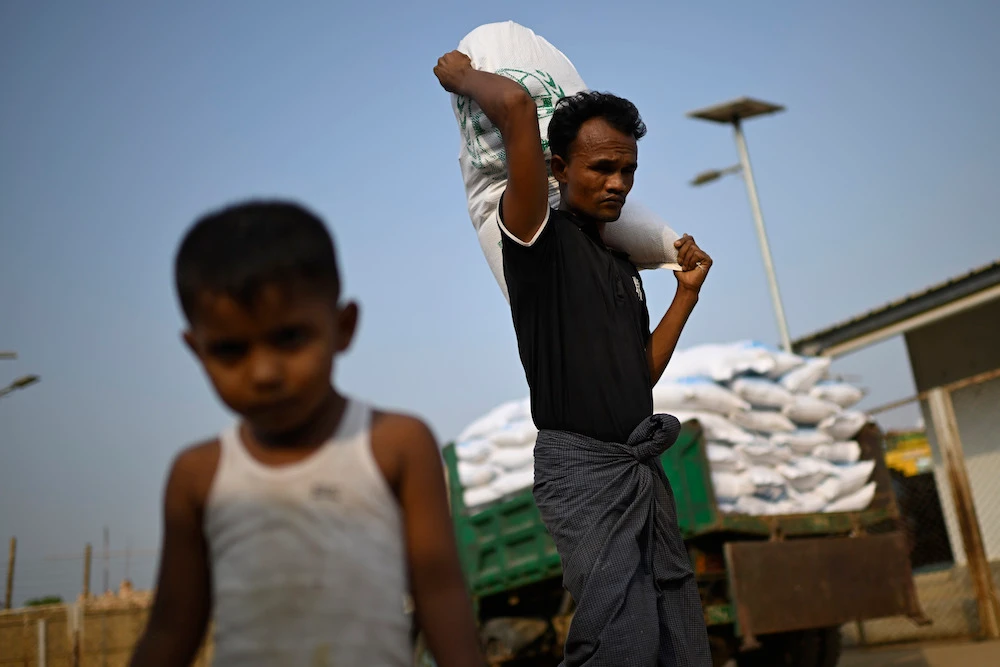 Rohingya refugee carries a food ration sack on his back from a distribution center in Cox's Bazar. (AP)