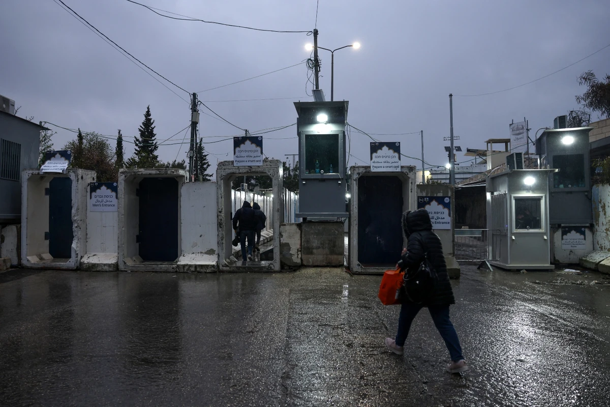 Palestinians cross an Israeli army checkpoint in Bethlehem in the occupied West Bank (File/AFP)