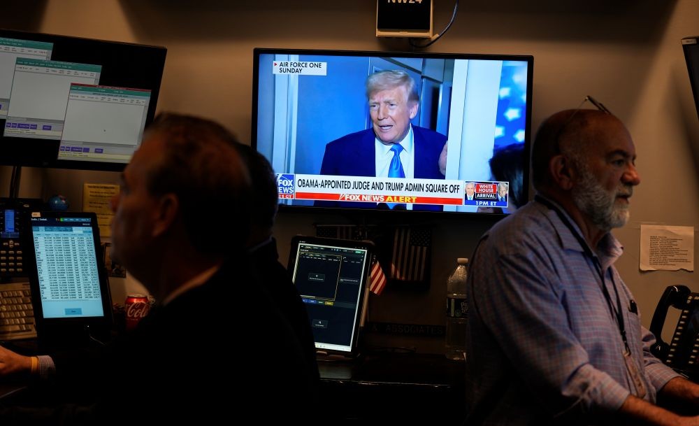 Donald Trump is visible on a TV screen as traders work on the floor of the New York Stock Exchange, Apr. 7, 2025. (AP Photo)