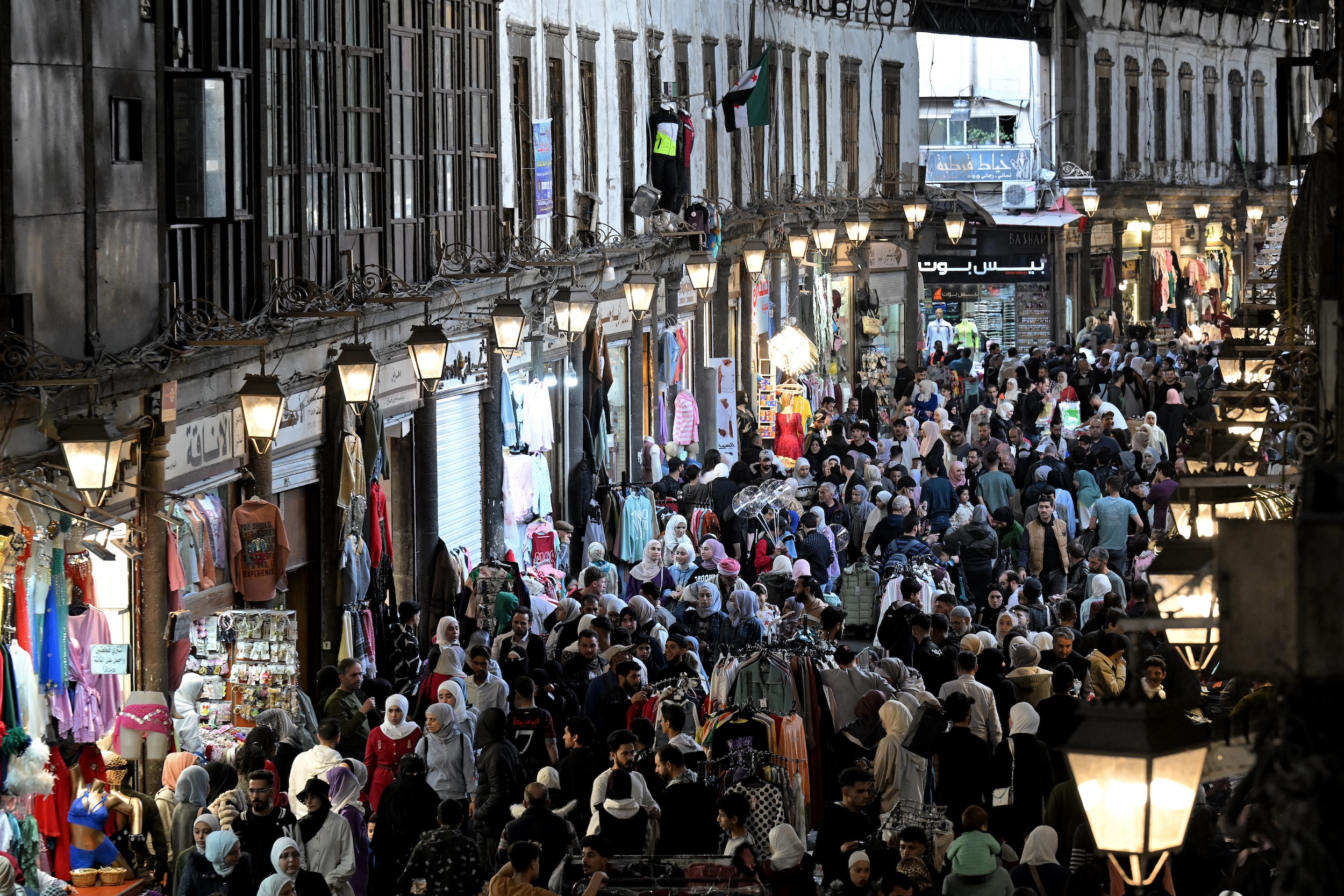 Shoppers walk browsing for items along the alley of Damascus' Hamidiya covered market, Mar. 29, 2025. (AFP)