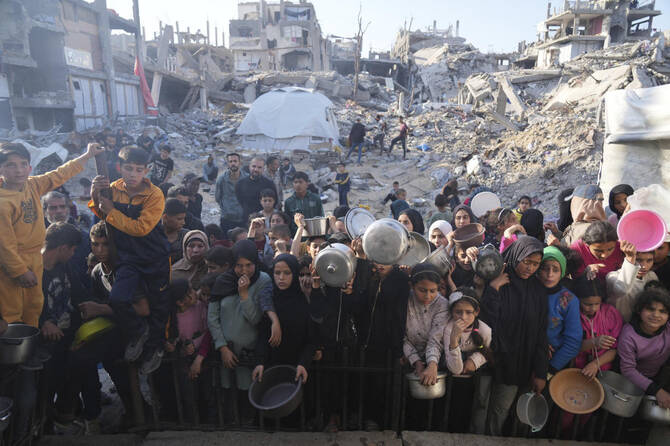 Palestinians wait for donated food at a distribution center in Beit Lahiya, northern Gaza Strip, Sunday, March 16, 2025. (AP)