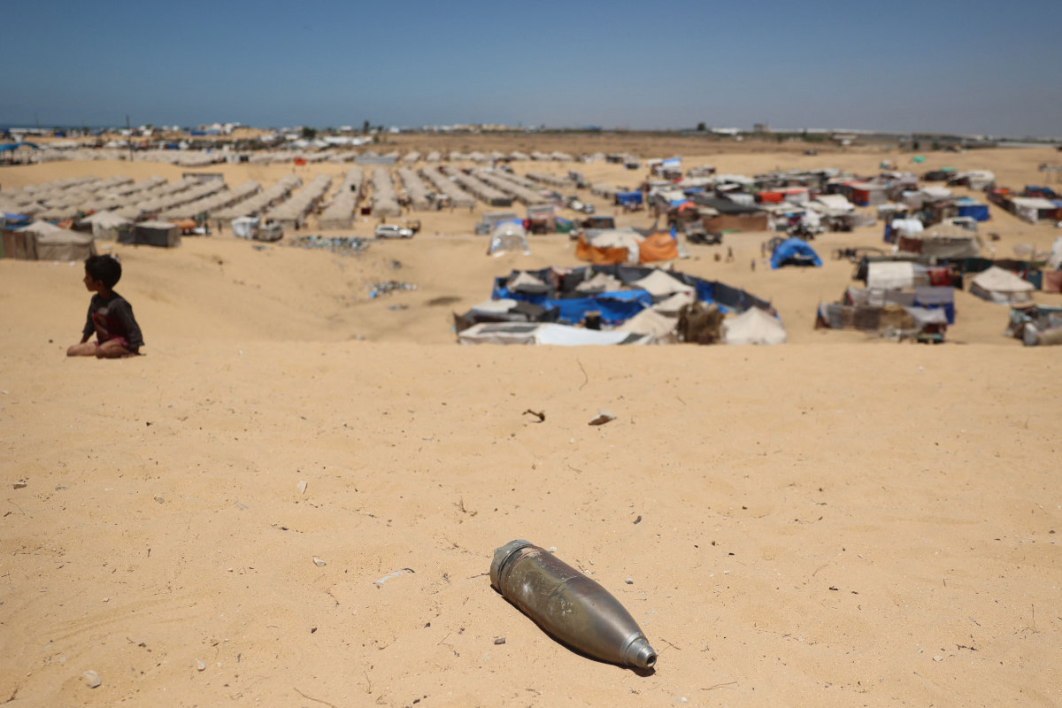 Civilians watch as Hamas ammunition experts collect unexploded ordnance found amid the rubble of destroyed buildings in the back of a pick in the eastern district of Khezaa in Khan Yunis in the southern Gaza Strip on November 24, 2023. (AFP)