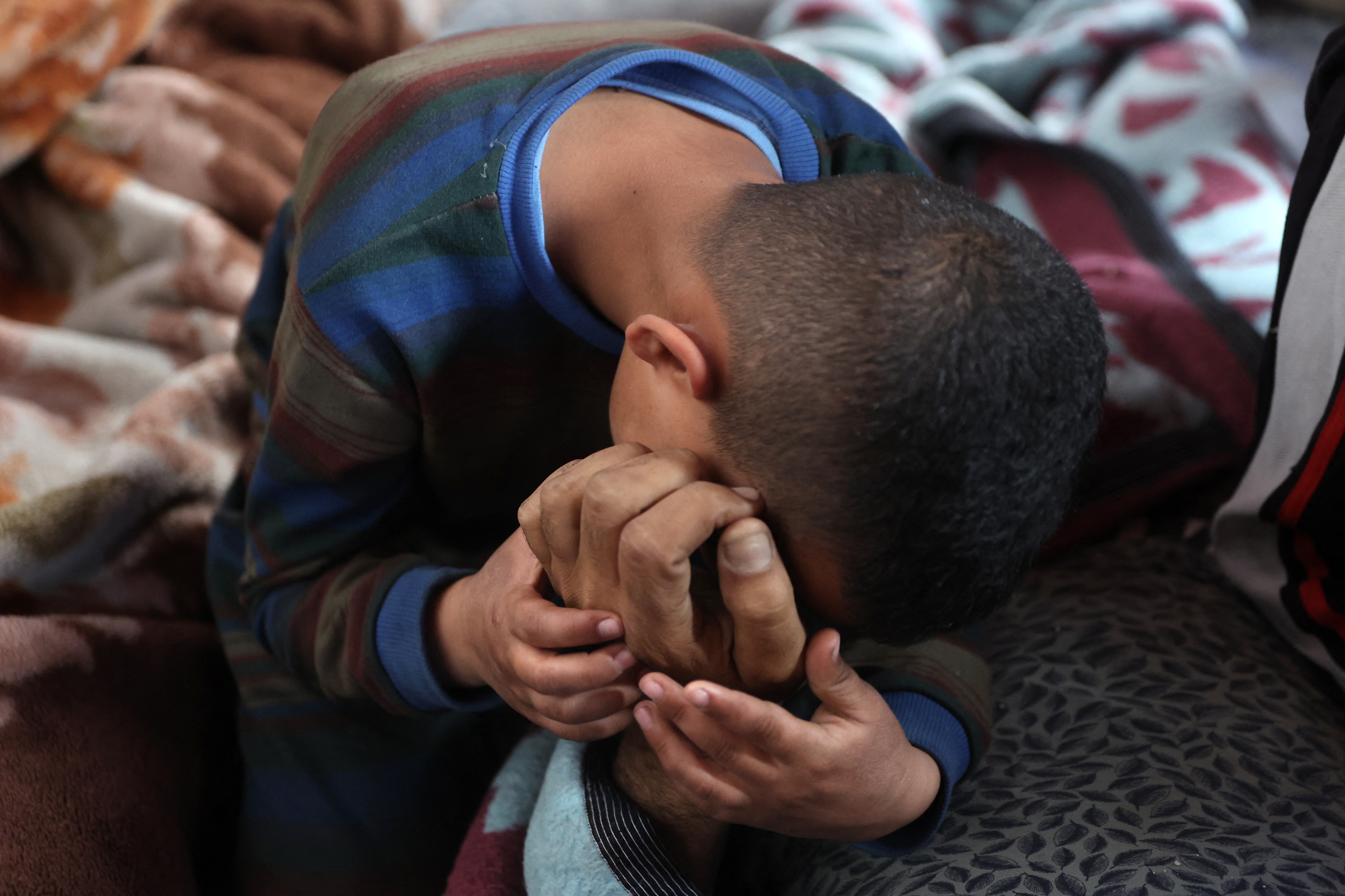 A boy mourns over the body of a loved one killed in overnight Israeli bombardment on northern Gaza, at the Ahli Arab Hospital, in Gaza City, Apr. 3, 2025. (AFP)
