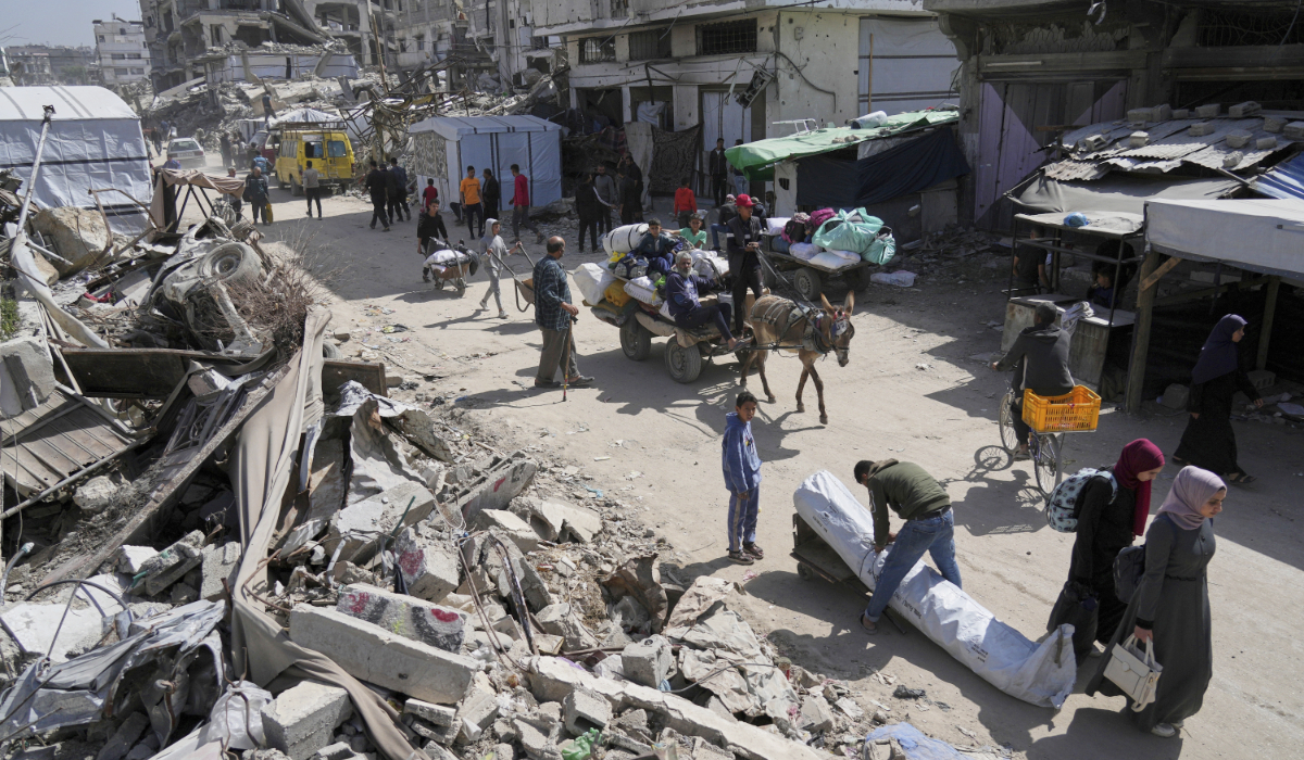 Palestinians carry their belongings as they evacuate Gaza’s Shijaiyah neighborhood following evacuation warnings issued by the Israeli army on Thursday. (AP)