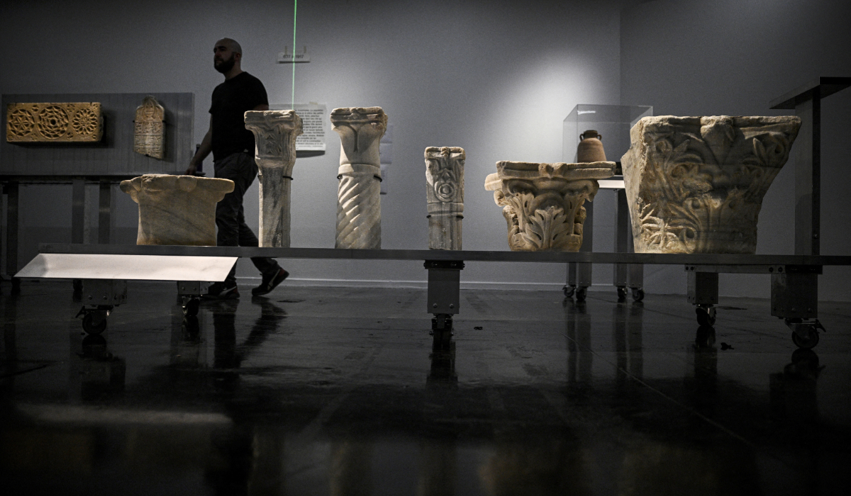 A man walks among the antiques during the installation of the archaeological heritage exhibition "Treasures saved from Gaza - 5000 years of history" (Tresors sauves de Gaza - 5000 ans d'histoire) at the Institut du Monde Arabe, in Paris, on March 31, 2025. (AFP)