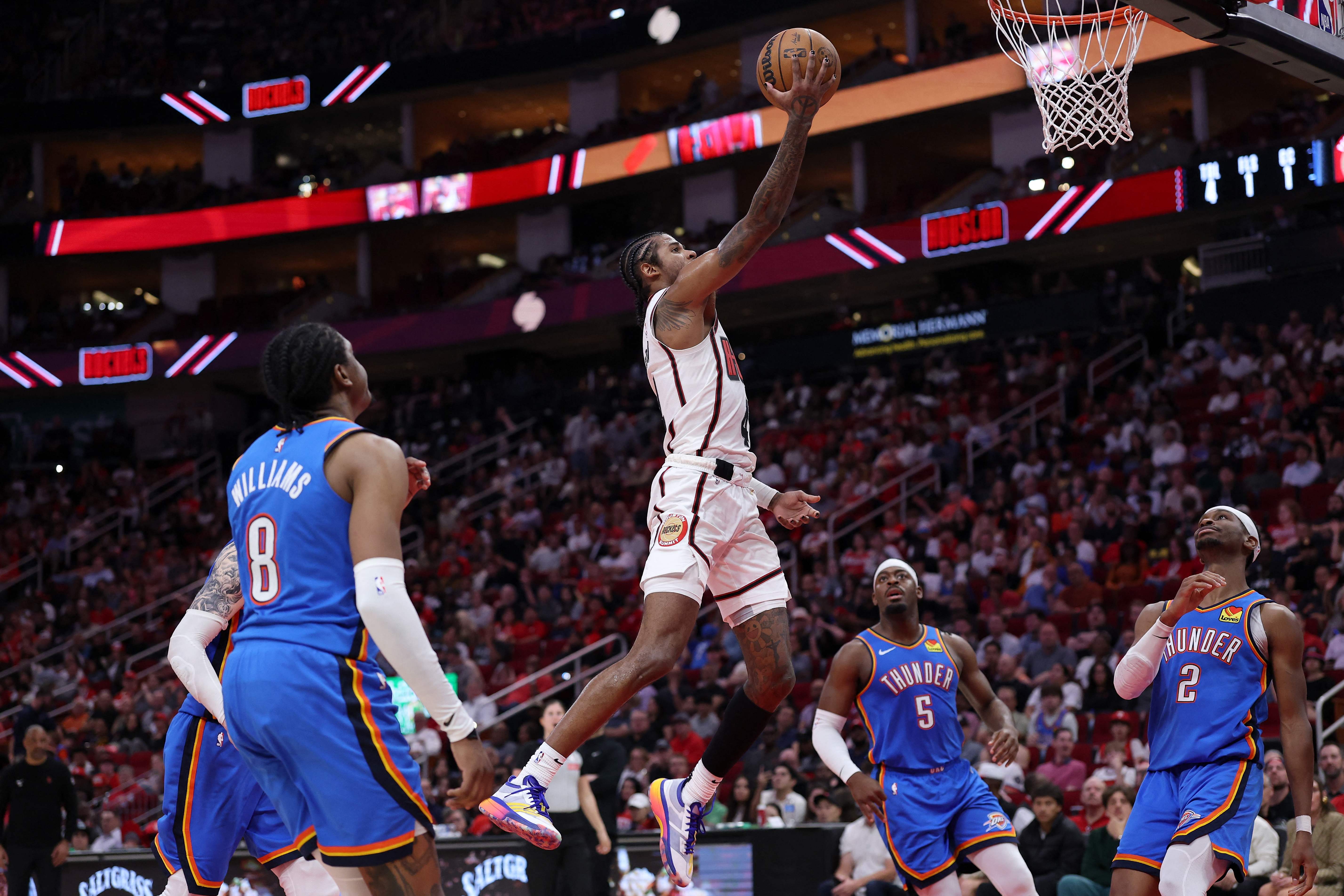 Jalen Green of the Houston Rockets goes up for a lay up in front of Luguentz Dort #5 of the Oklahoma City Thunder and Shai Gilgeous-Alexander #2 in the second half of an NBA game at Toyota Center on Friday in Houston, Texas. (Getty Images via AFP)