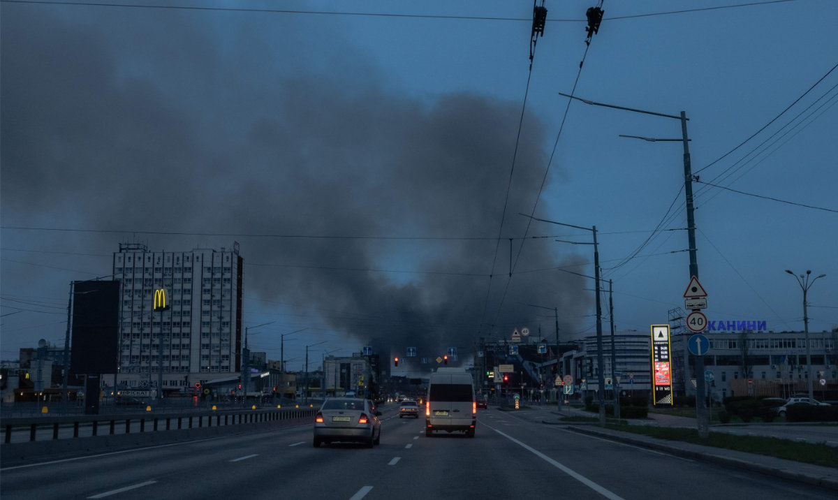 Cars drive on a road as smoke rises in the distance, following the Russian missile attack, in Kyiv on April 6, 2025, amid the Russian invasion of Ukraine. (AFP)