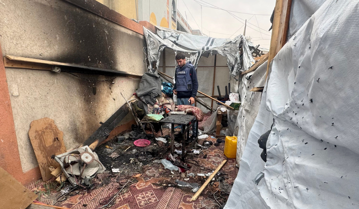 A Palestinian journalist inspects the debris and damage after an Israeli strike hit a tent used by journalists in the southern city of Khan Yunis on April 7, 2025. (AFP)