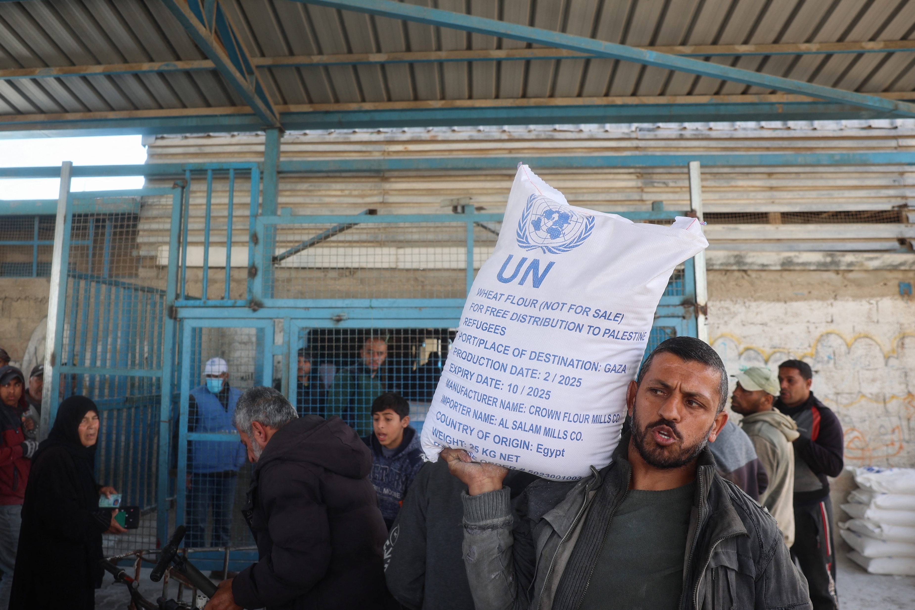Palestinians receive food aid from an UNRWA distribution center at the Nuseirat refugee camp in the central Gaza Strip, Mar. 3, 2025. (AFP)