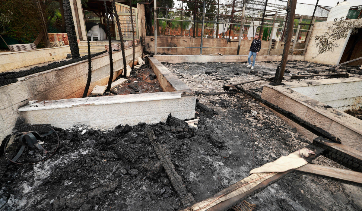 A Palestinian man walks in a burnt building after a reported attack by Israeli settlers, in the village of Sadya near the West Bank city of Salfit on April 8, 2025. (AFP)