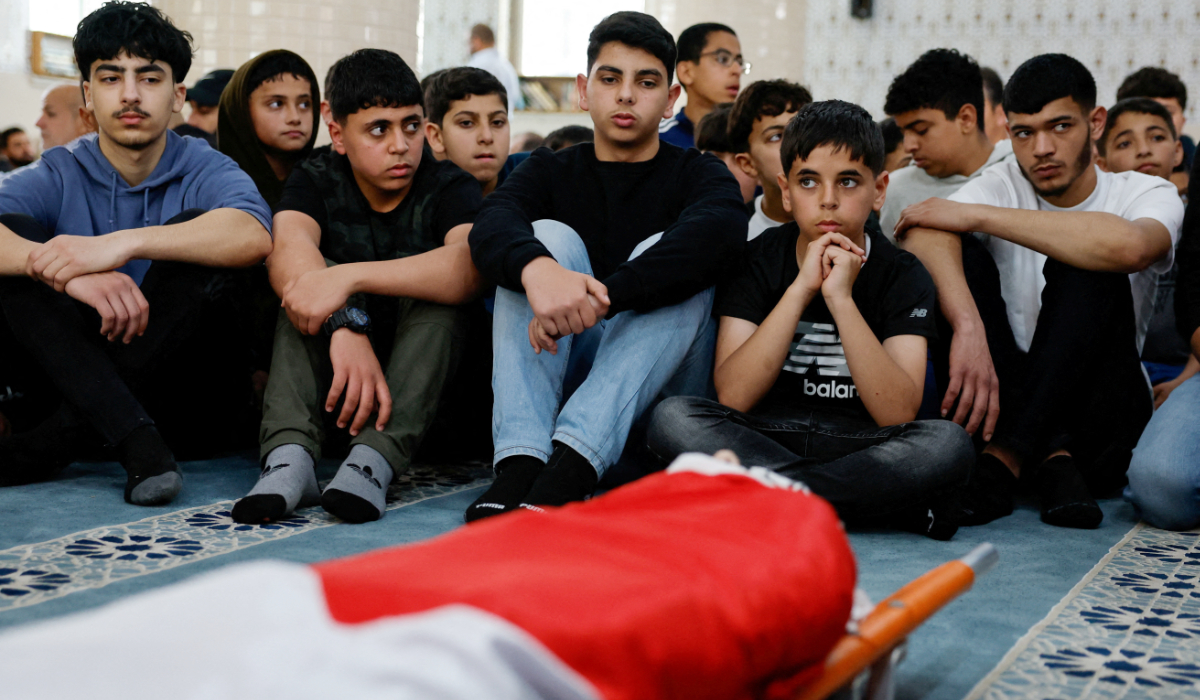 Youth mourn around the body of Palestinian-American boy Omar Mohammad Rabea, 14, who was killed by Israeli forces in Turmus Ayya village, during his funeral, near Ramallah in the Israeli-occupied West Bank April 7, 2025. (REUTERS)