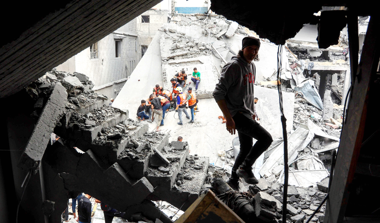 A man walks amidst the rubble of a building as rescuers work at the site of an Israeli strike in a residential area in Gaza City’s Shejaiya neighborhood. (AFP)