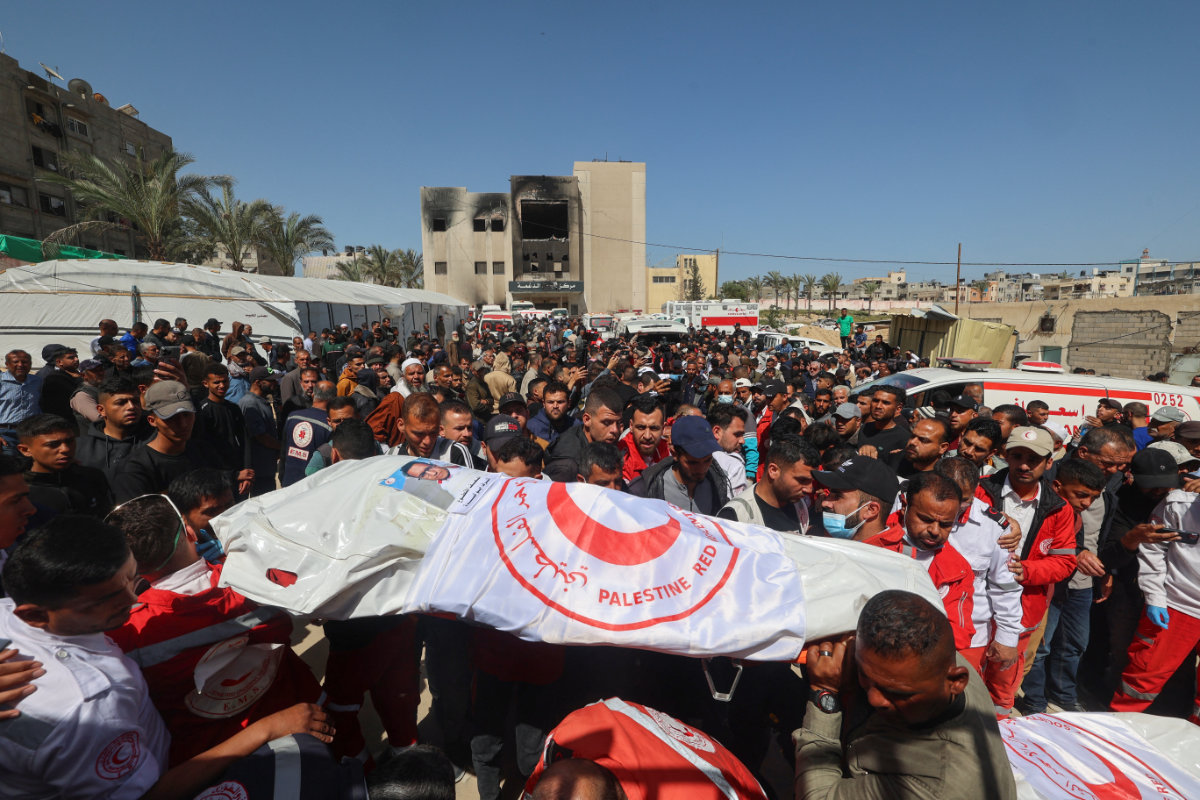 Members of the Palestine Red Crescent and other emergency services carry bodies of fellow rescuers killed a week earlier by Israeli forces, during a funeral procession at Nasser hospital in Khan Yunis in the southern Gaza Strip on March 31, 2025. (AFP)