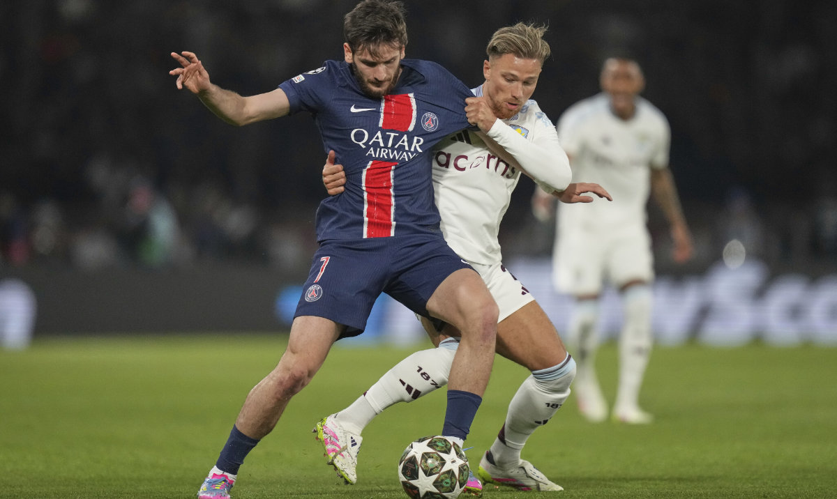 PSG's Khvicha Kvaratskhelia, left, challenges for the ball with Aston Villa's Matty Cash during the Champions League quarterfinal first leg soccer match between Paris Saint-Germain and Aston Villa at Parc des Princes stadium in Paris, Wednesday, April 9, 2025. (AP)