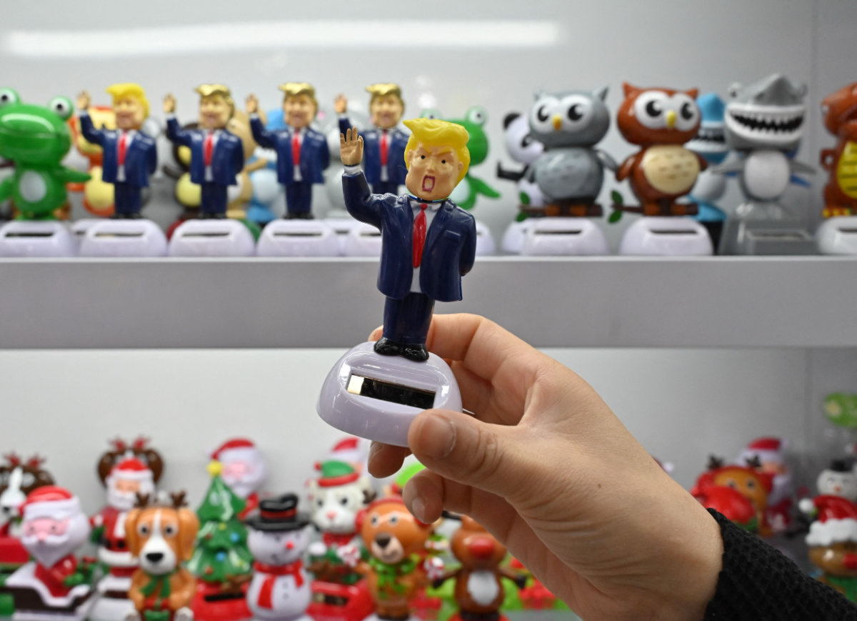 A shop owner holds a toy featuring US President Donald Trump at the Yiwu International Trade Market in Yiwu, China’s eastern Zhejiang province on April 10, 2025. (AFP)