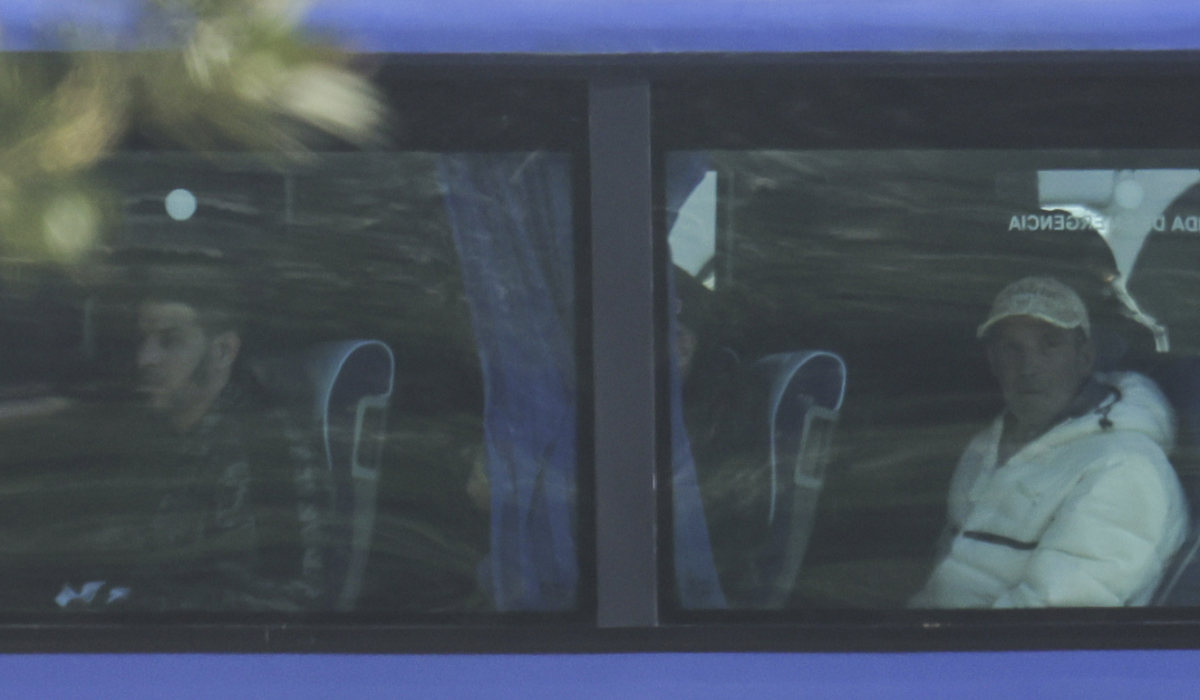 Migrants who arrived aboard the Italian navy ship Libra look out from a window of a bus as Italian authorities transfer 40 migrants with no permission to remain in the country to Italian-run migration detention centers in Albania, in Shengjin, northwestern Albania, Friday, April 11, 2025. (AP)