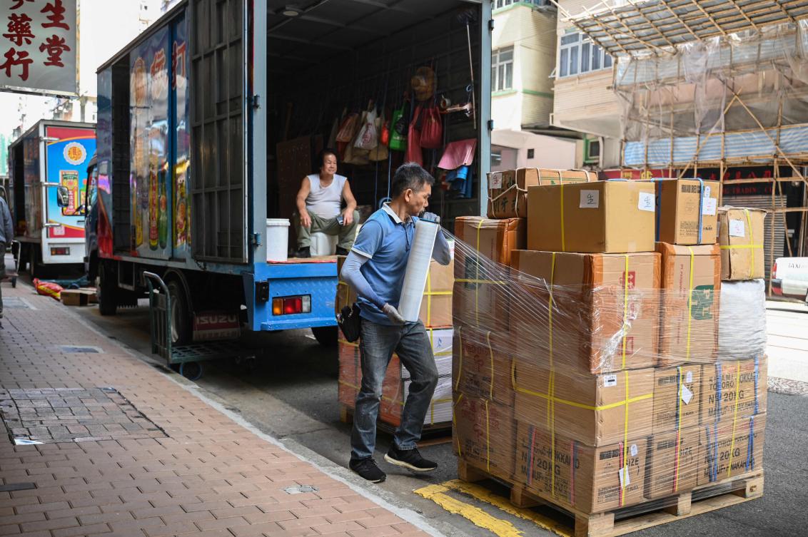 Above, a man wraps up goods on a street in Hong Kong on April 15, 2025. US President Donald Trump has increased the levies imposed on China to 145 percent. (AFP)
