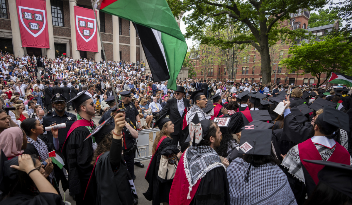 Graduating students hold Palestinian flags and chant as they walk out in protest over the 13 students who have been barred from graduating due to protest activities, during commencement in Harvard Yard, at Harvard University, in Cambridge, Mass., Thursday, May 23, 2024. (AP)
