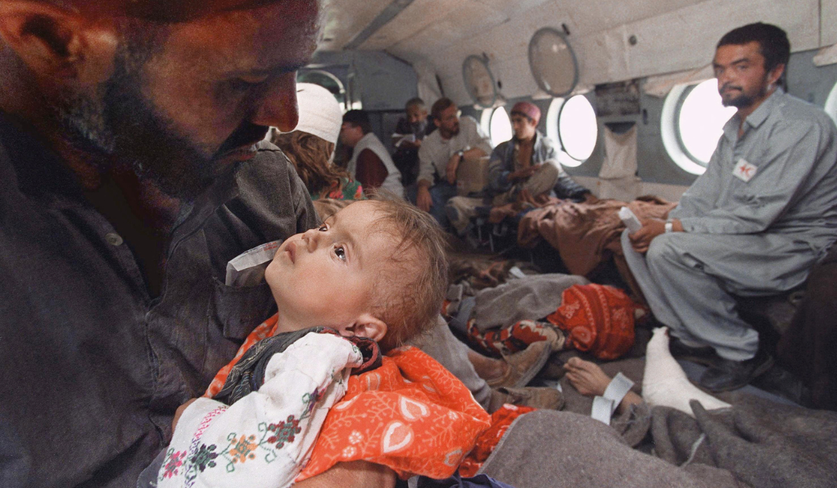 An injured Afghani girl is comforted while being evacuated by helicopter 02 June 1998 near Shuraq after a violent earthquake destroyed her village in northeast Aghanistan. (AFP file photo)