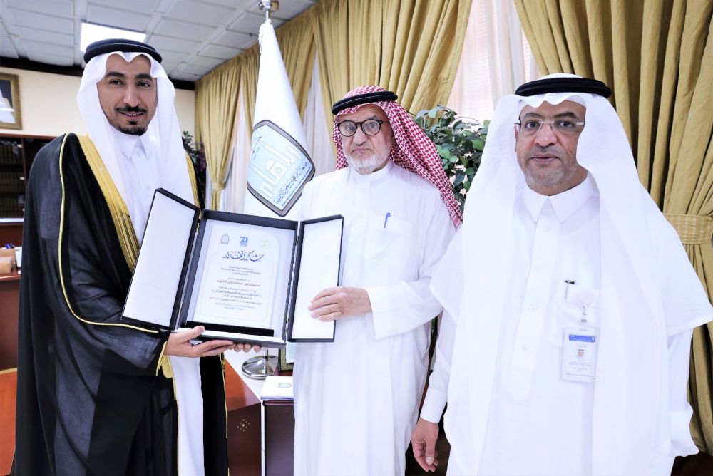 Dr. Abdullah Al-Asmari, left, vice rector for education affairs at IMSIU, delivered a certificate of appreciation to Dr. Sulaiman Al-Theeb, center, former professor of Arabian Peninsula Writings and Ancient Inscriptions at KSU. Dr. Khaled Al-Khara’n, dean of the College of Arabic Language at IMSIU is pictured on the right. (Supplied/ IMAMU)