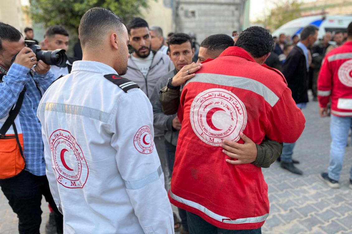 A paramedic embraces a youth as the bodies of Palestinian first responders, who were killed a week before in Israeli military fire on ambulances, arrive at Nasser Medical Complex in Khan Yunis in the southern Gaza Strip on March 30, 2025. (File/AFP)