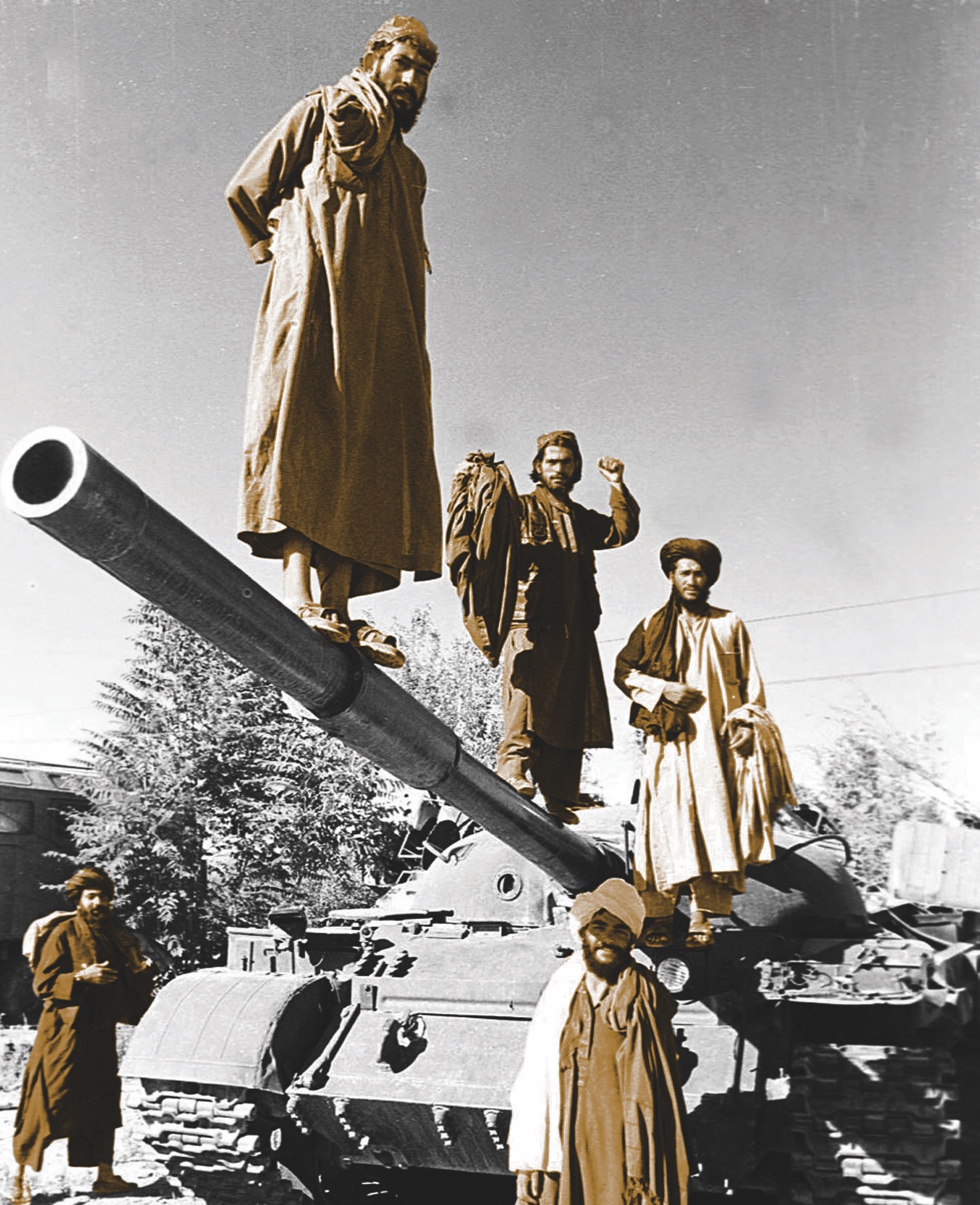 Afghan Taliban fighters pose on their military tank 25 kms north of Kabul. AFP