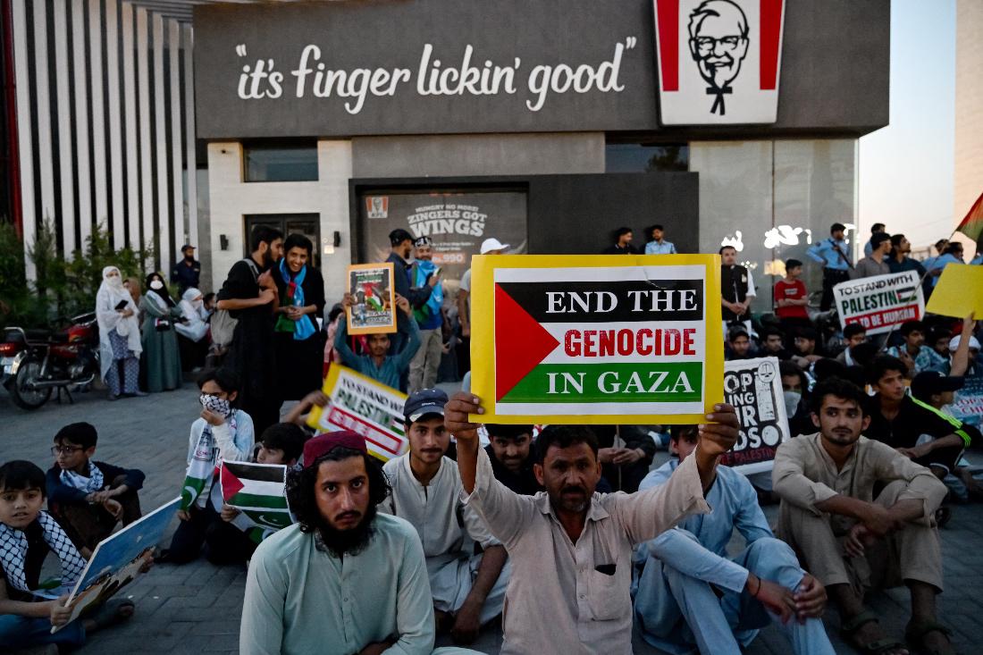 Supporters of Islami Jamiat-e-Talaba, a student wing of Pakistan's Jamaat-e-Islami party, stage a pro-Palestinian protest outside a KFC. (AFP)
