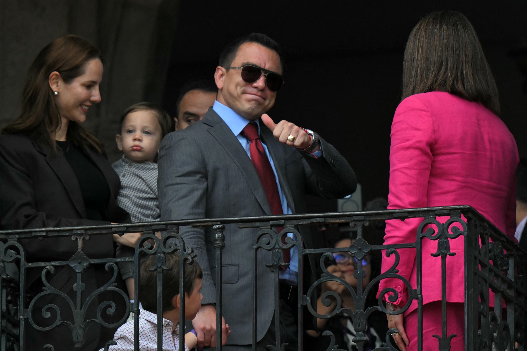 Ecuador's President-reelect Daniel Noboa (C) gives the thumb up to supporters, accompanied by his wife, Lavinia Valbonesi (L), his sons Alvaro and Furio, and Vice-President-reelect Maria Jose Pinto, from a balcony of the Carondelet Presidential Palace during the changing of the guard ceremony in Quito on April 15, 2025. (AFP)