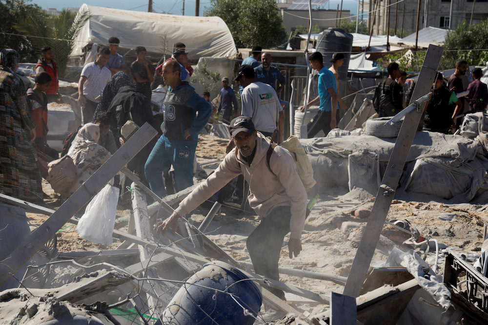 Palestinians inspect the damage at the site of an Israeli strike on a tent camp sheltering displaced people, in Khan Younis, southern Gaza Strip, April 19, 2025. (Reuters)