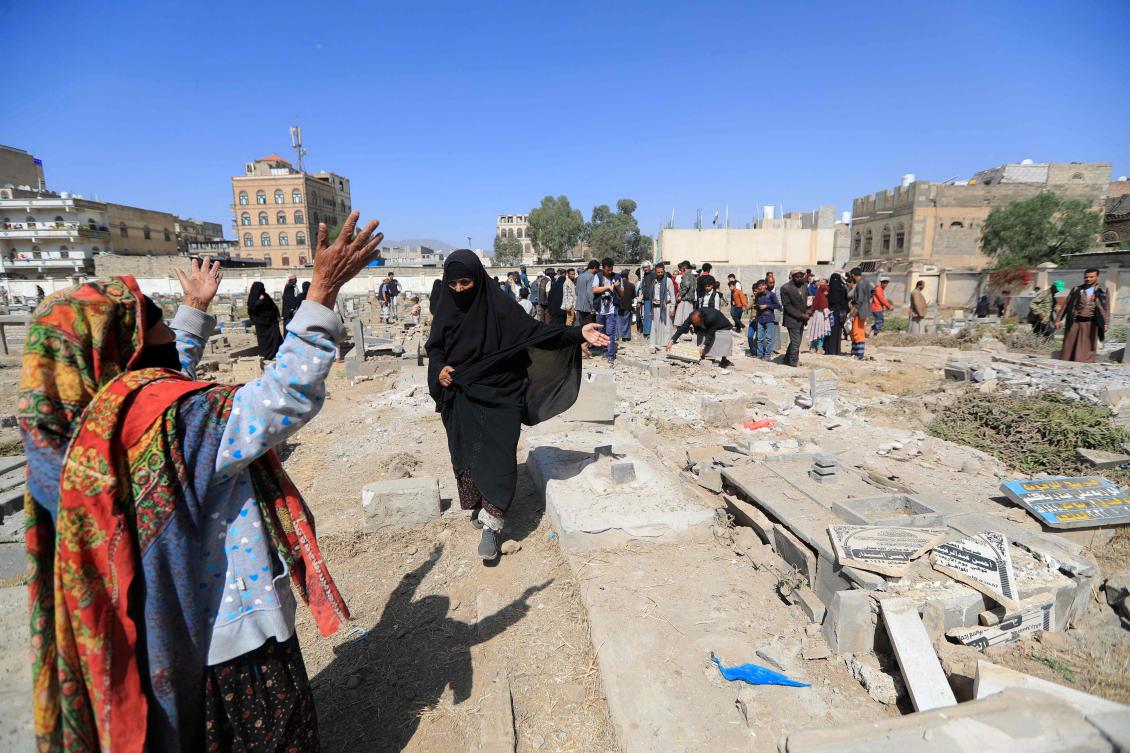 People assess the damaged cause by a reported strike in Yemen’s Houthi-held capital Sanaa on April 20, 2025. (AFP)