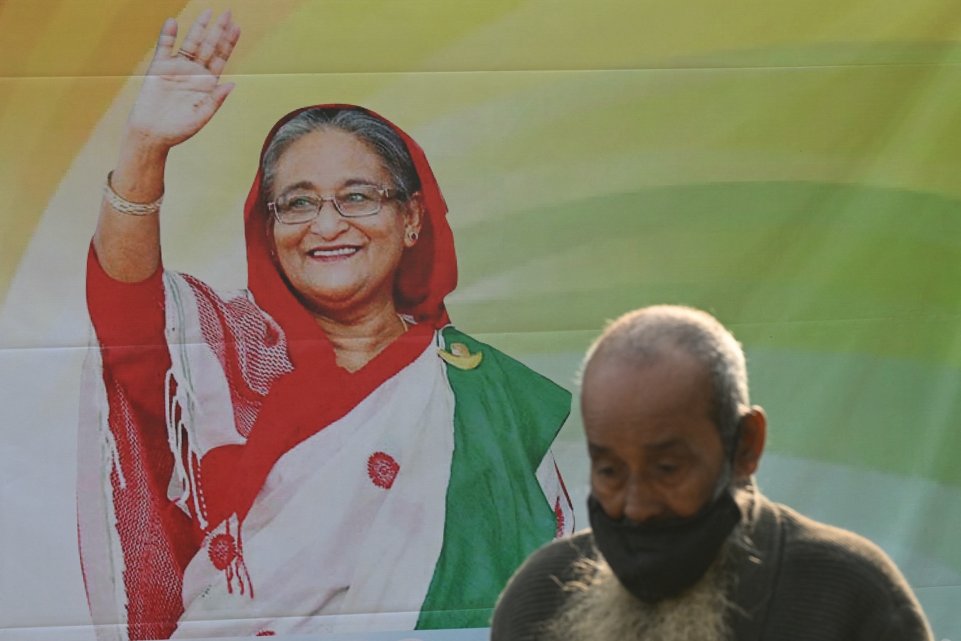 A man walks past a poster of the Awami League party featuring its leader Sheikh Hasina in Dhaka, Bangladesh, on Jan. 5, 2024. (AFP)