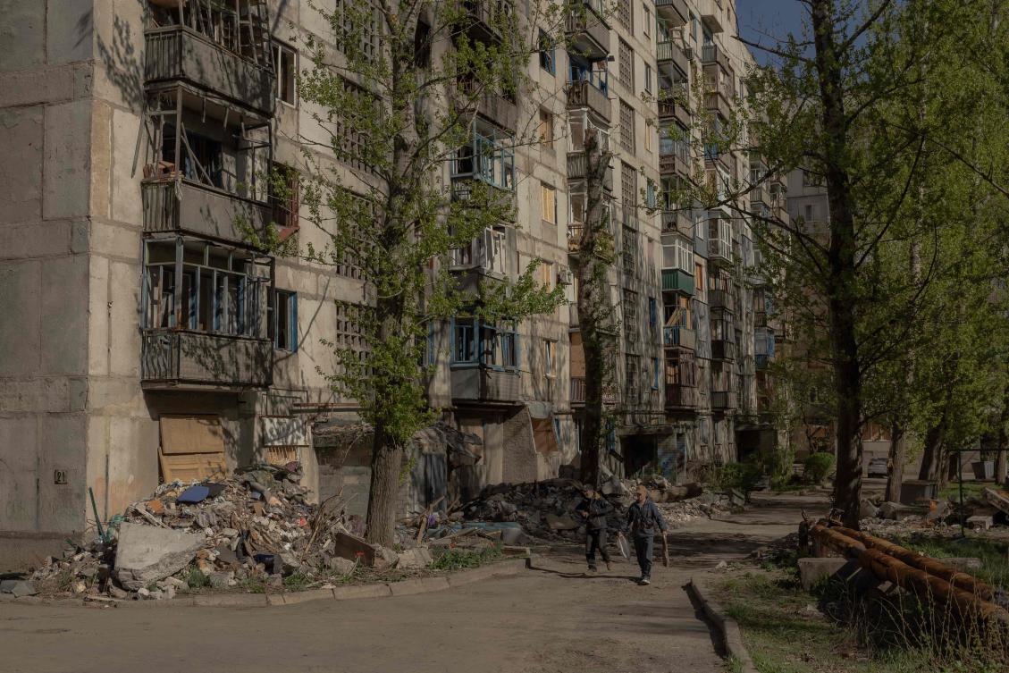 People walk past residential buildings heavily damaged by air attacks in Kostyantynivka, in the eastern Donetsk region, on April 20, 2025. (AFP)