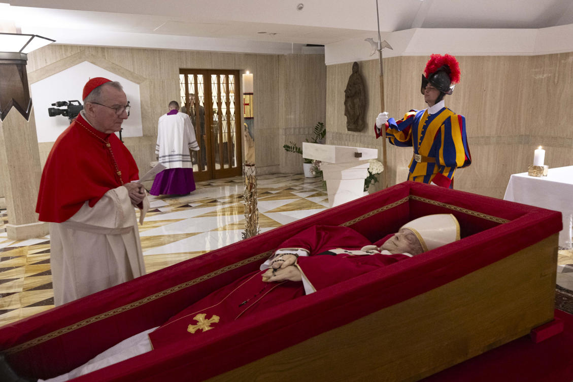 Vatican Secretary of State Cardinal Pietro Parolin, left, prays in front of the body of Pope Francis laid out in state inside his private chapel at the Vatican on April 21, 2025. (Vatican Media via AP)