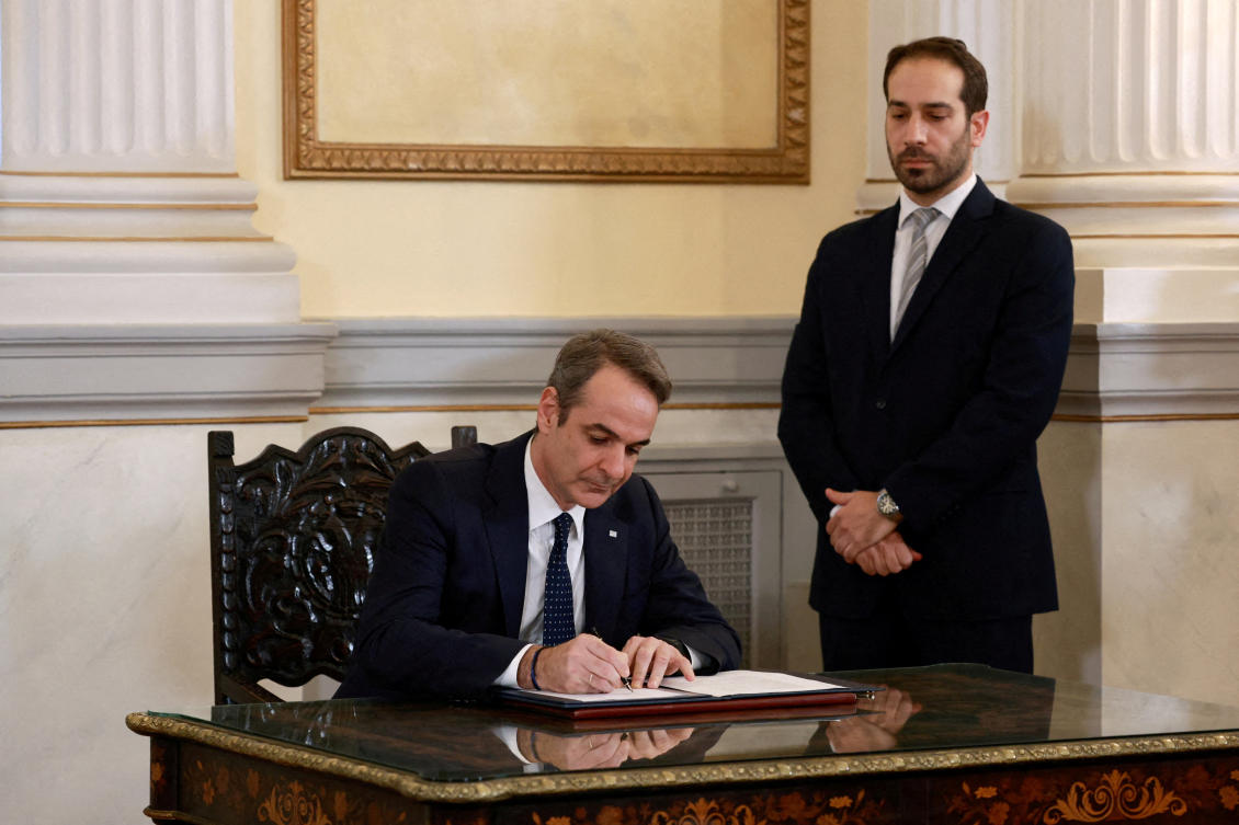 Greek Prime Minister Kyriakos Mitsotakis signs a document during a swearing-in ceremony of the newly appointed members of the government, Mar. 15, 2025. (Reuters)
