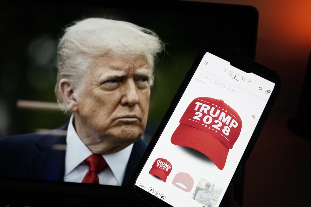 Illustration of US President Donald Trump alongside a smartphone displaying a red 'Trump 2028' cap on the Trump Store website. (AFP)