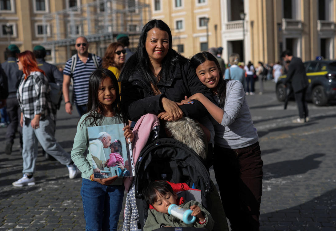 Francezka Abano, 9, holds a picture of her and Pope Francis from 2018, as she poses for a picture with her mother Diane Karla Abano, her sister Sophia, 9, and her brother John Florence, 2, in Rome, Apr. 24, 2025. (Reuters)