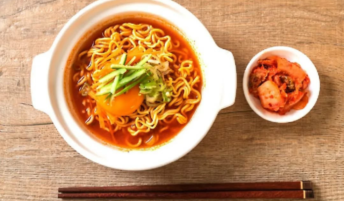 A warm bowl of comfort — spicy jjampong ramen topped with fresh veggies and served with kimchi on the side. This is what cozy cravings are made of. (Supplied)