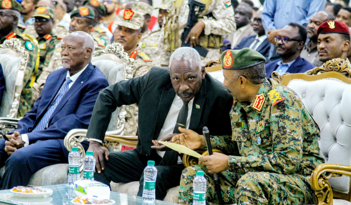 Sudan's army chief General Abdel Fattah al-Burhan (R) speaks with Defence Minister Major-General Yassin Ibrahim (C) as they attend the inauguration of an initiative to support the families of victims killed and injured in the ongoing civil war, in Port Sudan on April 26, 2025. (AFP)